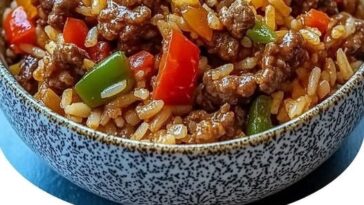 "Delicious beef and bell peppers stir-fried with rice, served in a bowl with fresh herbs and a savory sauce."