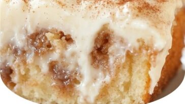 "Delicious cinnamon roll poke cake with gooey cinnamon filling and a sweet glaze on top"