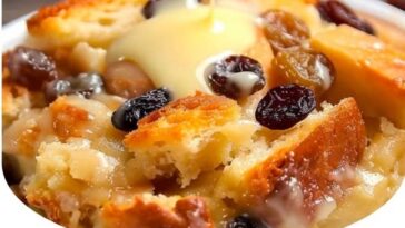 "Delicious serving of Classic New Orleans Bread Pudding with a golden-brown crust, drizzled with rich vanilla sauce, and garnished with a dusting of cinnamon. A comforting southern dessert perfect for any occasion."