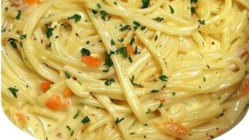 "Bowl of crack chicken noodle soup with tender chicken, noodles, creamy broth, and a sprinkle of cheese, garnished with fresh herbs."