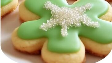 "Soft, sweet cream cheese sugar cookies topped with colorful sprinkles, freshly baked and placed on a plate."