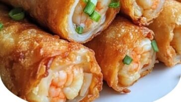 "Crunchy homemade shrimp egg rolls with a golden, crispy exterior, filled with shrimp, vegetables, and seasonings served on a plate with dipping sauce."