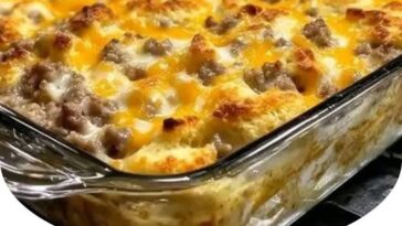 A hearty serving of Biscuits and Gravy Hashbrown Breakfast Casserole with golden hashbrowns, creamy sausage gravy, and fluffy biscuit layers, topped with melted cheese.