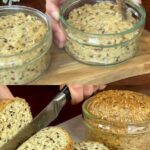 A small jar containing freshly baked bread, golden brown and fluffy, with a smooth crust and a rustic appearance, ready to be served.