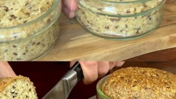 A small jar containing freshly baked bread, golden brown and fluffy, with a smooth crust and a rustic appearance, ready to be served.