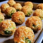Crispy, golden-brown Cheesy Broccoli Bites arranged on a plate, with melted cheese and vibrant green broccoli visible inside, served with a dipping sauce on the side.