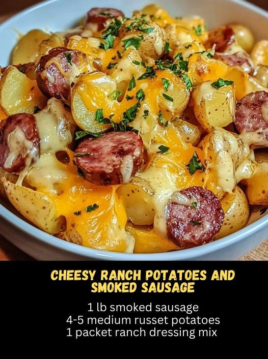 plate of cheesy ranch potatoes and smoked sausage, featuring golden, crispy potatoes topped with melted cheese, and slices of savory smoked sausage scattered throughout.