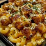 bowl of creamy, cheesy mac and cheese topped with tender, grilled honey pepper chicken, drizzled with extra honey and pepper sauce, garnished with fresh herbs.