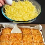 Golden-baked rustic potato slices topped with herbs and cheese, served in a rustic dish.
