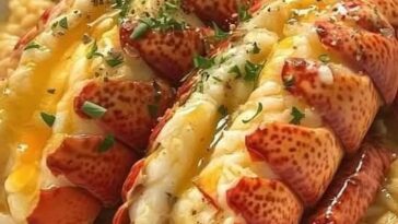 Succulent lobster tails and scallops drizzled with rich garlic butter, garnished with fresh herbs and served on a plate.