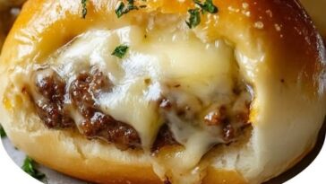 Garlic Parmesan Cheeseburger Bombs, golden and crispy on the outside with melted cheese and seasoned beef inside, garnished with fresh garlic and Parmesan.