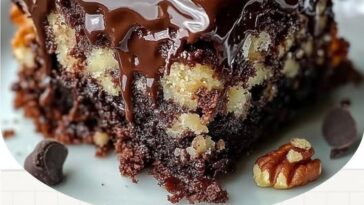 German Chocolate Poke Cake with rich caramel sauce drizzled over the top, topped with chocolate frosting and coconut-pecan filling