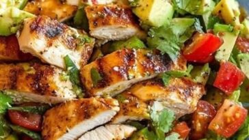 A fresh Grilled Chicken Avocado Salad with grilled chicken slices, creamy avocado, mixed greens, and vibrant vegetables, drizzled with a zesty dressing.
