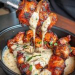 Tender grilled chicken bites drizzled with rich, creamy garlic sauce, served as a flavorful and easy-to-make dish