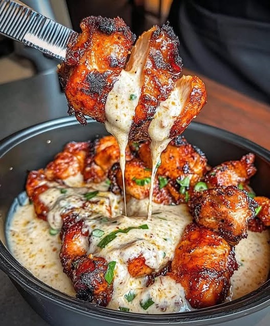 Tender grilled chicken bites drizzled with rich, creamy garlic sauce, served as a flavorful and easy-to-make dish