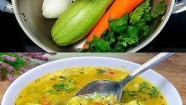 Healthy healing vegetable soup with carrots, zucchini, spinach, and sweet potato, garnished with fresh herbs.