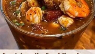 A bowl of Louisiana Seafood Gumbo filled with shrimp, crab, and sausage, simmered in a rich, dark roux with vegetables, served with a side of rice.
