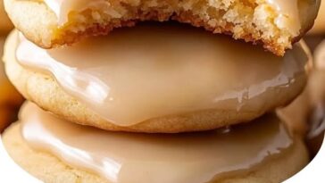 Maple cookies topped with a glossy maple icing, arranged on a plate with a rustic, warm background.