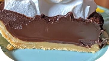 Old fashioned chocolate pie topped with a golden, fluffy meringue, showcasing a rich, smooth chocolate filling in a flaky pie crust