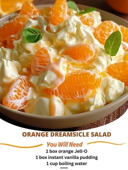 A creamy orange dreamsicle salad with orange segments, whipped cream, and a fluffy texture, served in a bowl.