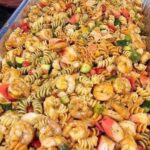 Colorful and refreshing pasta salad with shrimp, crab, fresh vegetables, and a light dressing, perfect for a summer meal.