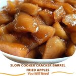 A bowl of Slow Cooker Cracker Barrel Fried Apples, caramelized with cinnamon and sugar, garnished with a sprinkle of cinnamon, served with a spoon, exuding a warm, comforting aroma.