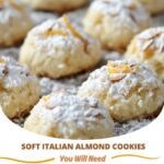 A plate of soft Italian almond cookies, dusted with powdered sugar and garnished with whole almonds, showcasing their delicate texture and light golden color.