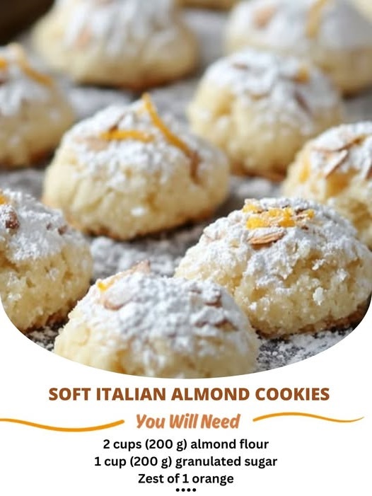 A plate of soft Italian almond cookies, dusted with powdered sugar and garnished with whole almonds, showcasing their delicate texture and light golden color.