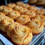 Soft and buttery milky coconut biscuits stacked on a plate, with a golden brown exterior and a light, fluffy interior.