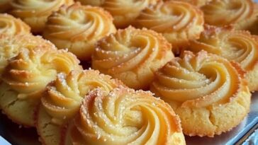 Soft and buttery milky coconut biscuits stacked on a plate, with a golden brown exterior and a light, fluffy interior.
