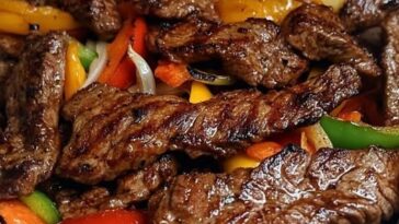 Sizzling steak fajitas served on a hot skillet, with colorful bell peppers, onions, and warm tortillas on the side