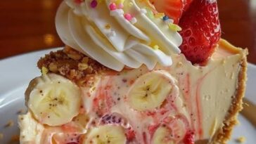 slice of banana strawberry cheesecake on a plate, with a creamy cheesecake layer, fresh banana slices, and vibrant strawberry topping.