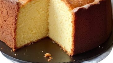 golden-brown slice of homemade pound cake on a white plate, showing a moist, dense texture and buttery crumb.