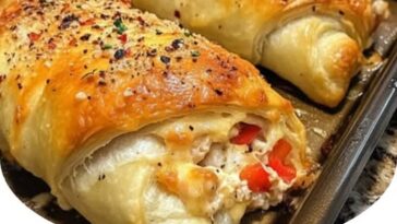 Golden, flaky crescent rolls stuffed with tender chicken and cheese, fresh out of the oven, with a light golden crust.