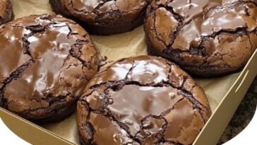 Chocolate brownie mix cookies stacked on a plate, with a cracked, fudgy surface and rich, dark color.