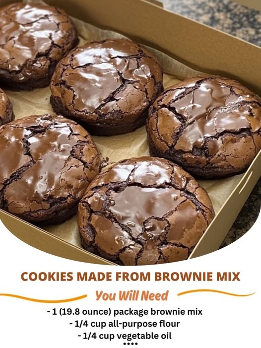 Chocolate brownie mix cookies stacked on a plate, with a cracked, fudgy surface and rich, dark color.