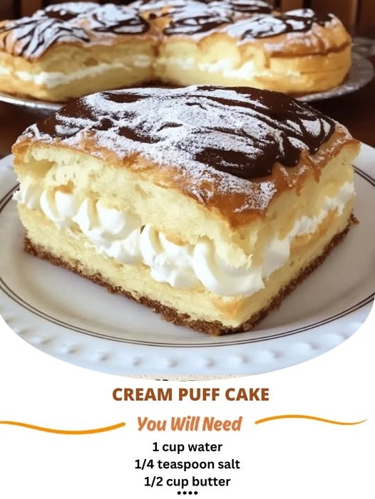 A slice of cream puff cake with a light, fluffy texture, topped with creamy filling and a drizzle of chocolate.