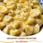 Crockpot filled with creamy, cheesy potatoes topped with melted cheese and fresh herbs.