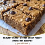 Stack of healthy peanut butter Greek yogurt blondies on a white plate, drizzled with peanut butter and sprinkled with oats.