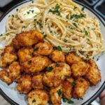 Tender honey pepper chicken served alongside creamy garlic butter pasta, garnished with fresh herbs and a drizzle of sauce.