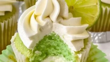 Delicious key lime cupcakes with a light, fluffy texture, topped with a creamy swirl of lime frosting and a small lime slice garnish.