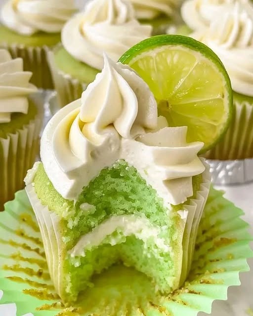 Delicious key lime cupcakes with a light, fluffy texture, topped with a creamy swirl of lime frosting and a small lime slice garnish.