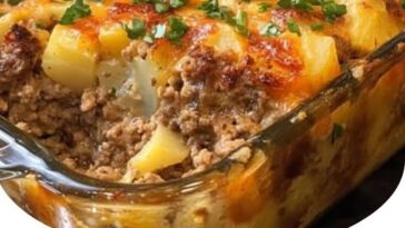 A hearty slice of loaded potato and meatloaf casserole topped with melted cheese, crispy bacon bits, and chopped green onions.
