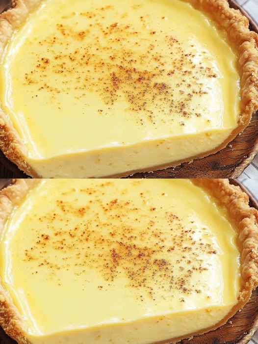 A golden-brown old-fashioned custard pie with a flaky crust, sliced to reveal a smooth, creamy filling.