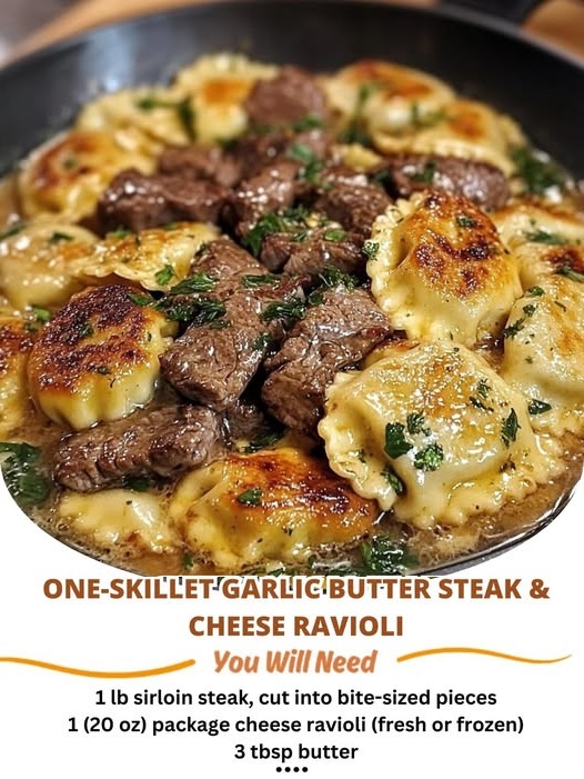 sizzling skillet filled with tender steak pieces and cheese ravioli in a rich garlic butter sauce, garnished with fresh herbs.