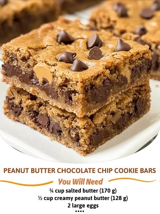 A close-up of chewy peanut butter chocolate chip cookie bars, with chocolate chips and a golden-brown crust, sliced into squares.