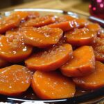 Southern candied sweet potatoes glazed with a rich syrup of butter, brown sugar, and spices, served in a dish with a caramelized finish.