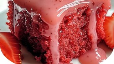 A moist strawberry glaze cake topped with a glossy layer of vibrant strawberry glaze, garnished with fresh strawberries.