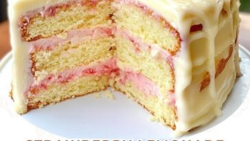 Strawberry lemonade buttermilk cake topped with fresh strawberries and a light glaze, sliced and ready to serve.