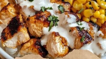 vibrant bowl of street corn chicken rice, featuring grilled chicken, seasoned rice, corn, and colorful toppings, creating a delicious and savory meal.